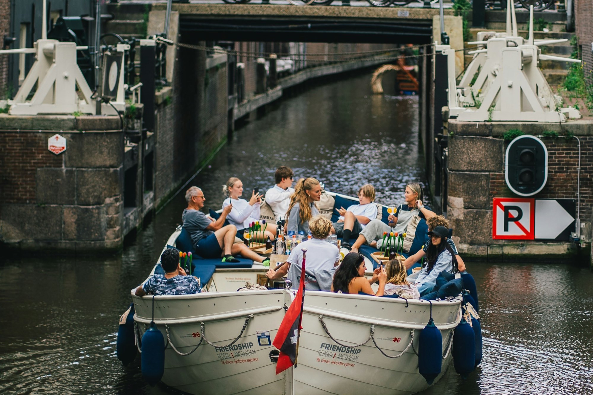 Vrienden varen in een open sloep door de gracht